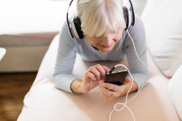 Mujer encantadora en auriculares con smartphone