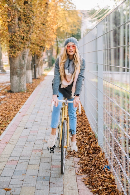 Mujer encantadora en bicicleta cerca de la cerca