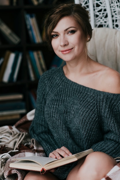 Mujer encantadora con buen libro mirando a la cámara