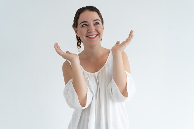 Mujer encantadora feliz levantando las manos