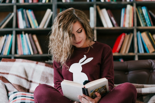 Mujer encantadora leyendo en el sofá