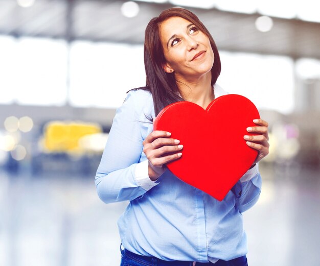 Mujer encantadora mirando hacia arriba con un corazón