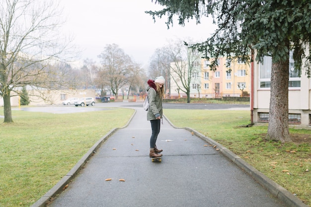 Mujer encantadora montando patineta