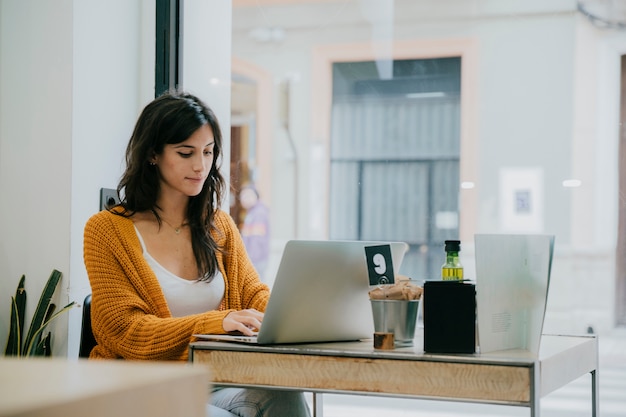 Mujer encantadora, navegación, computadora portátil, en, café