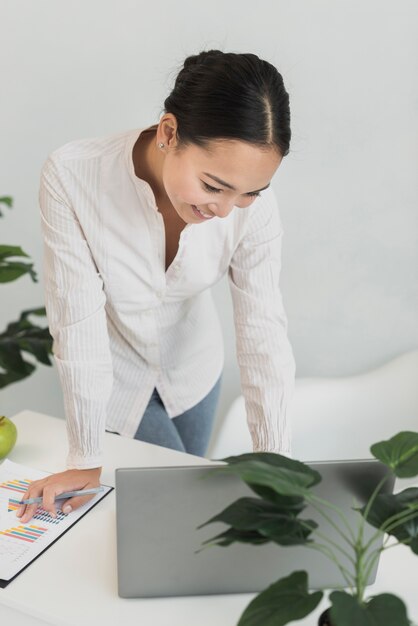 Mujer encantadora que controla la computadora portátil