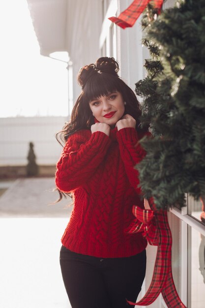 Mujer encantadora en suéter rojo al aire libre