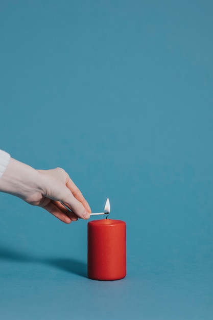 Mujer encendiendo una vela roja