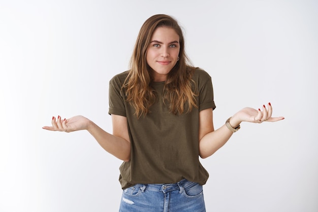 Mujer encogiéndose de hombros con las manos extendidas hacia los lados inconscientes, cuestionada sonriendo disculpándose respuesta desconocida