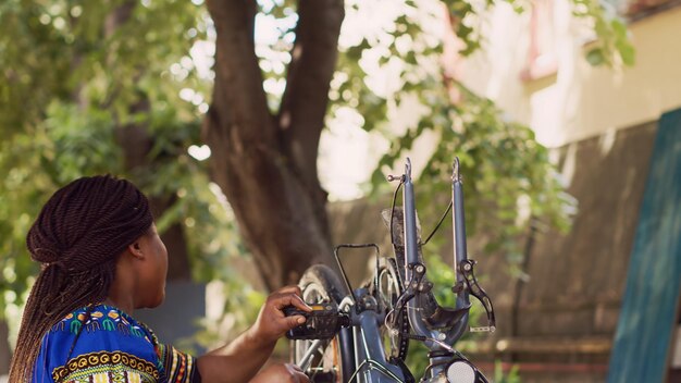 Foto gratuita mujer enérgica agarrando la rueda de una bicicleta