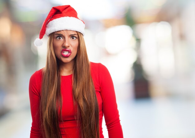 Mujer enfadada con el sombrero de papa noel en un centro comercial