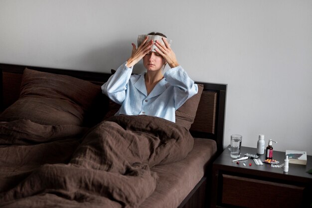 Mujer enferma en cama tiro medio