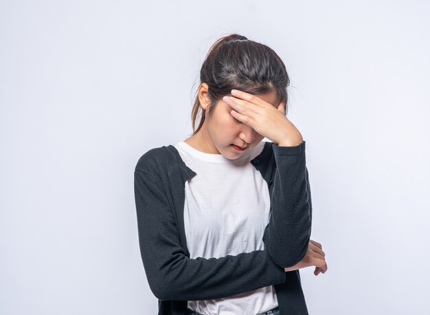 Una mujer enferma con dolor de cabeza y puso su mano sobre su cabeza.