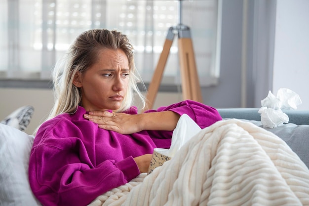 Foto gratuita mujer enferma con dolor de cabeza sentada debajo de la manta mujer enferma con infecciones estacionales alergia a la gripe acostada en la cama mujer enferma cubierta con una manta acostada en la cama con fiebre alta síntomas de coronavirus