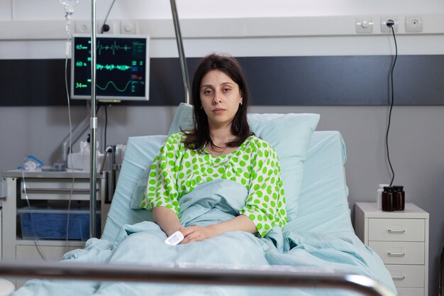 Mujer enferma mirando a la cámara en la cama