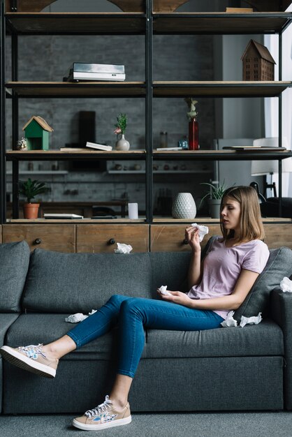 Foto gratuita mujer enferma sentada en la cama con papel de seda