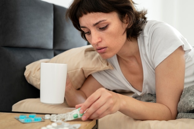 Mujer enferma de tiro medio con pastillas