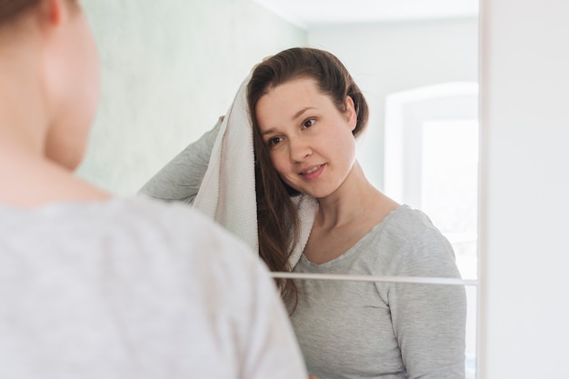 Mujer enfrente de espejo en baño