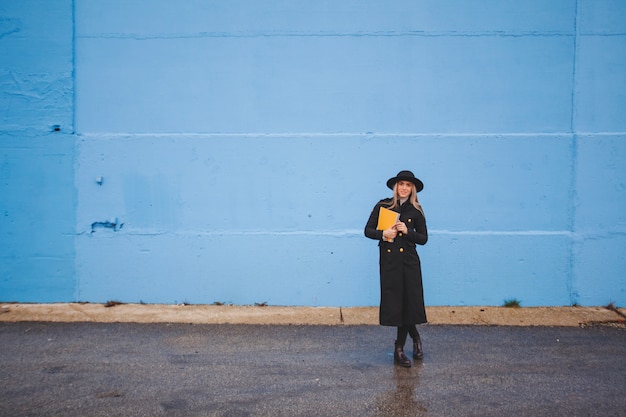 Foto gratuita mujer enfrente de un muro azul