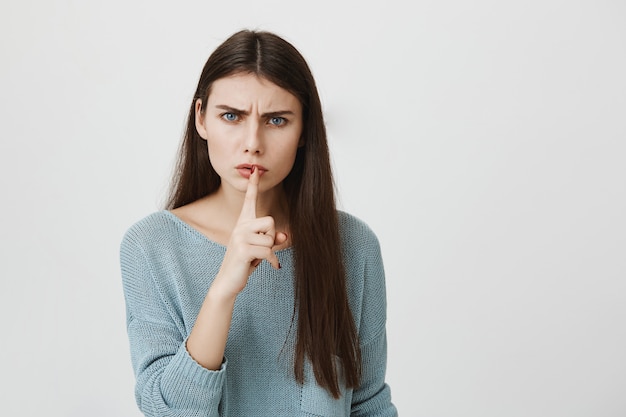 Mujer enojada frunciendo el ceño, silencio para callar