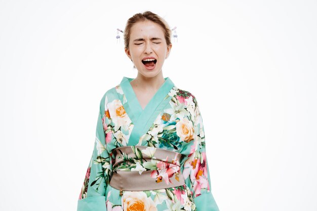 Mujer enojada en kimono japonés tradicional gritando y gritando en blanco