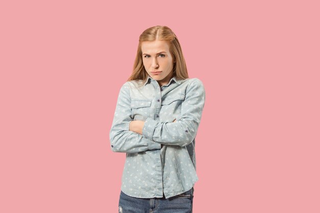 Mujer enojada mirando a cámara. Mujer de negocios agresiva que se encuentran aisladas sobre fondo de moda estudio rosa. Retrato femenino de medio cuerpo. Las emociones humanas, el concepto de expresión facial. Vista frontal.