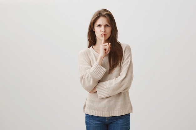 Mujer enojada que hace muecas decir que se calla, callar a la persona