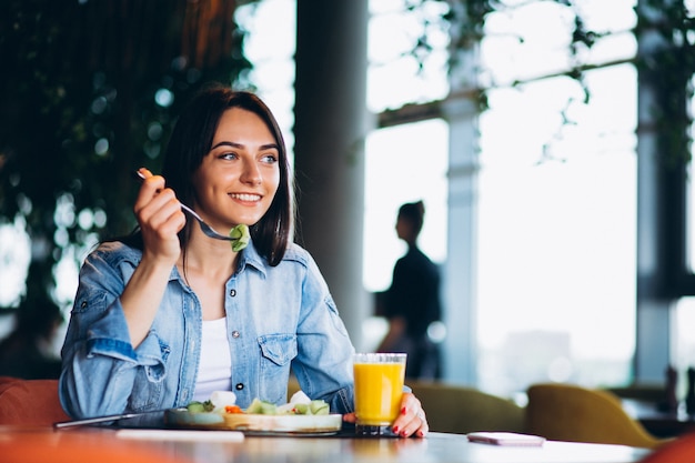 Mujer con ensalada y teléfono