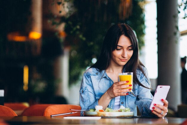 Mujer con ensalada y teléfono