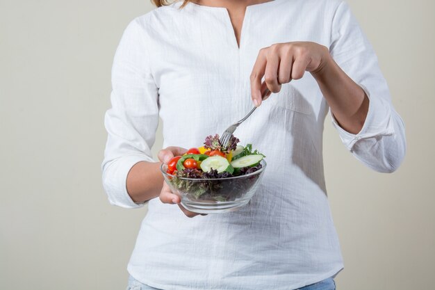 Mujer con una ensalada y un tenedor en la mano