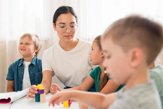 Mujer enseñando a los niños a jugar con juego colorido