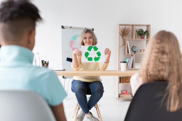 Mujer enseñando a los niños a reciclar