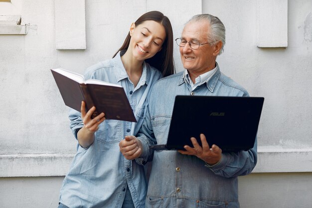 Mujer enseñando a su abuelo a usar una computadora portátil