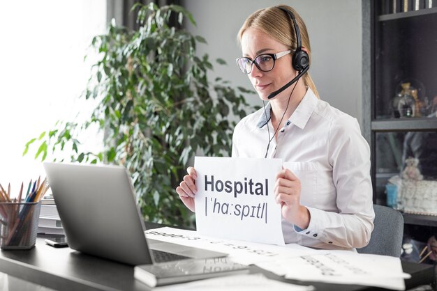 Mujer enseñando a sus alumnos la definición de hospital