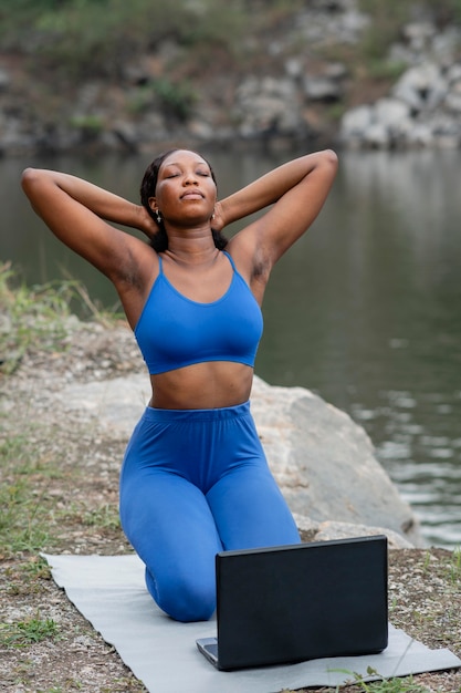 Foto gratuita mujer enseñando a sus estudiantes posturas de yoga