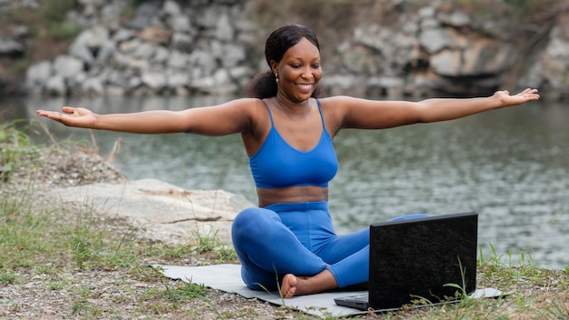 Mujer enseñando yoga a personas en línea