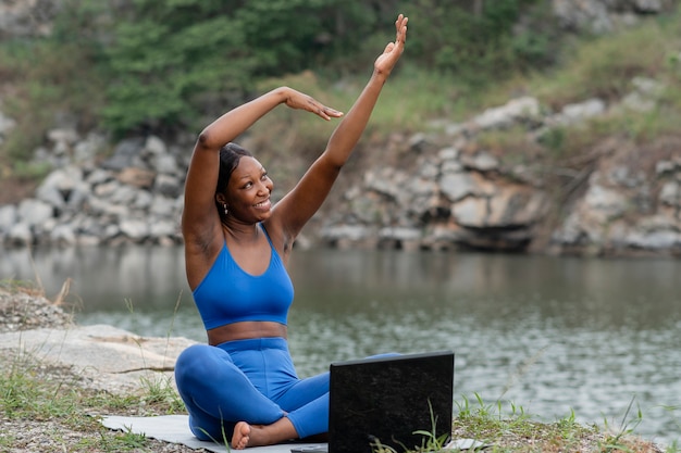 Mujer enseñando yoga a personas en línea
