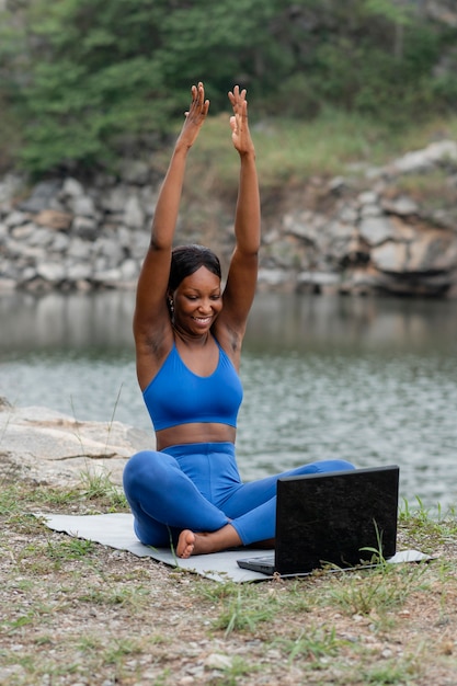 Mujer enseñando yoga a personas en línea