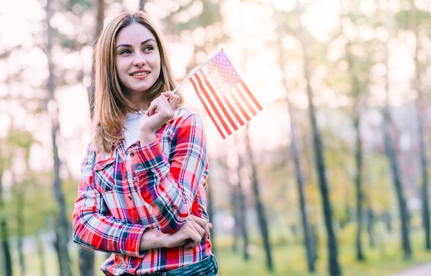 Foto gratuita mujer de ensueño con pequeña bandera americana.