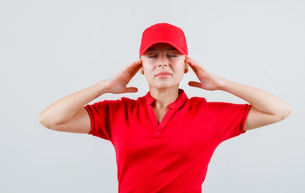 Mujer de entrega en camiseta roja y gorra tomados de la mano a la cabeza y mirando relajado