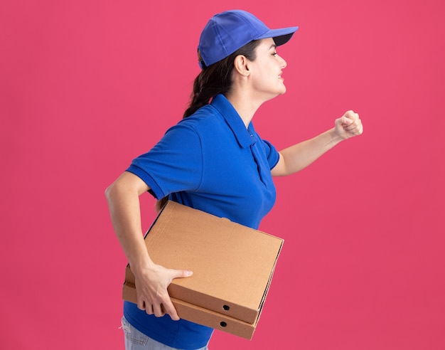 Mujer de entrega joven complacida en uniforme y gorra