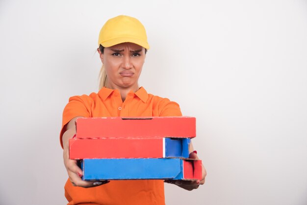 Mujer de entrega de pizza con cajas de pizza sobre fondo blanco.