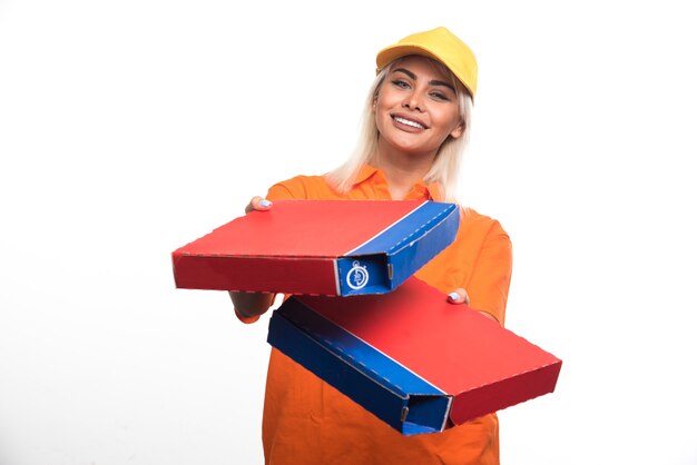 Mujer de entrega de pizza sosteniendo pizza sobre fondo blanco mientras los mira. Foto de alta calidad