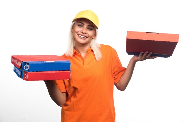 Mujer de entrega de pizza sosteniendo pizza sobre fondo blanco mientras sonríe. Foto de alta calidad