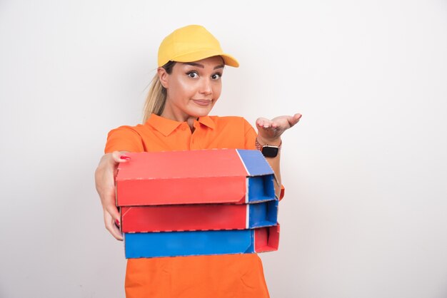Mujer de entrega rubia sosteniendo cajas de pizza en el espacio en blanco