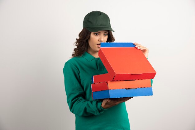 Mujer de entrega sorprendentemente mirando pizza.