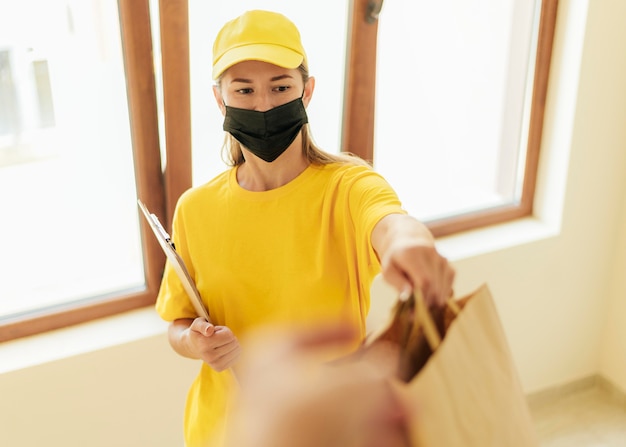 Mujer de entrega de tiro medio sosteniendo bolsas