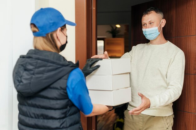 Mujer de entrega de tiro medio sosteniendo cajas