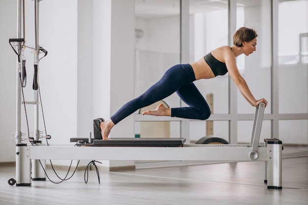 Mujer con entrenador de pilates practicando pilates