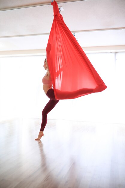 Mujer entrenamiento de yoga gimnástico con lino rojo