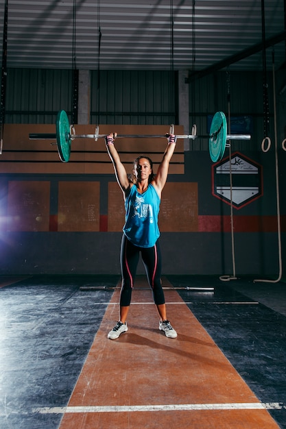 Foto gratuita mujer entrenando con barra de pesas
